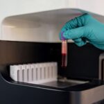 Lab technician takes a vial of blood.